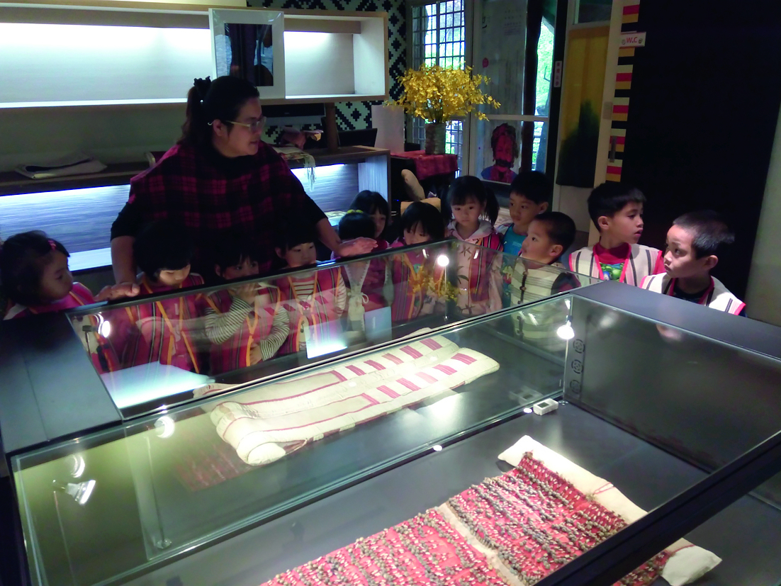 野桐工坊的專業管理人楊美珍為士林國小附設幼稚園的小朋友解說文物。